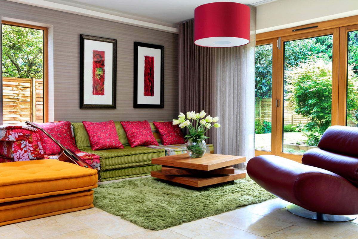 Guitar resting on a sofa in a stylish interior designed with rock n roll chic aesthetic by Peter Staunton